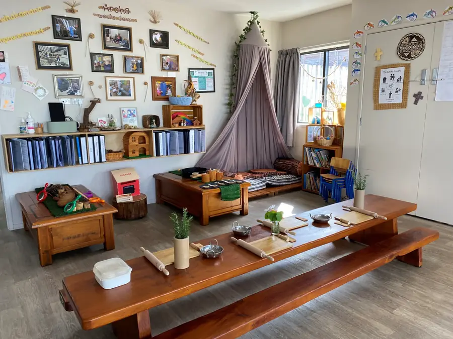 The Gecko Room for two year olds with a long wooden table, book shelves and home corner