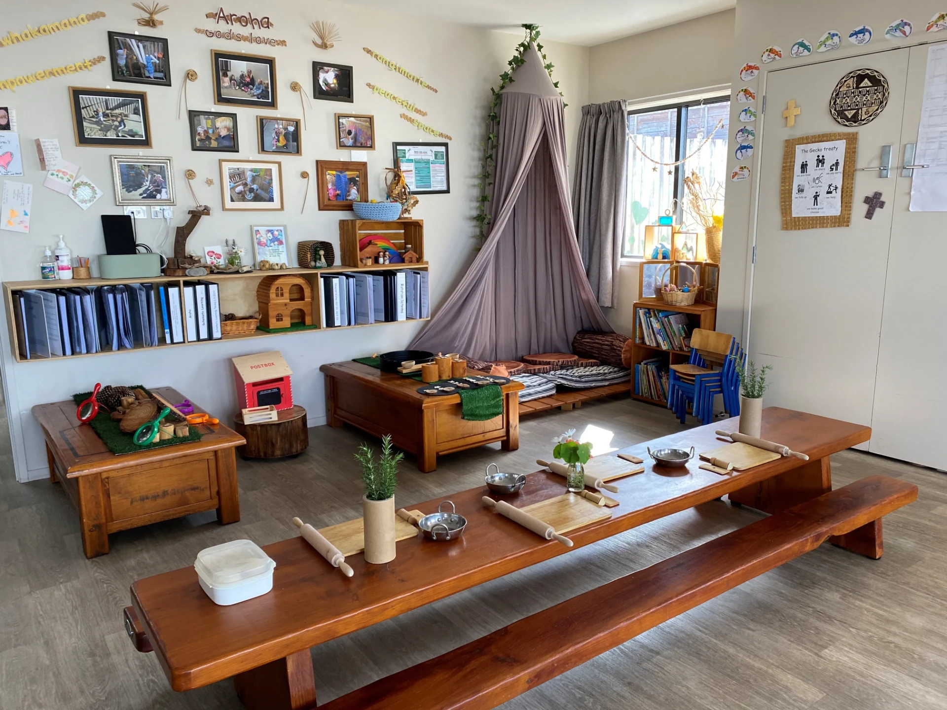 The Gecko Room for two year olds with a long wooden table, book shelves and home corner