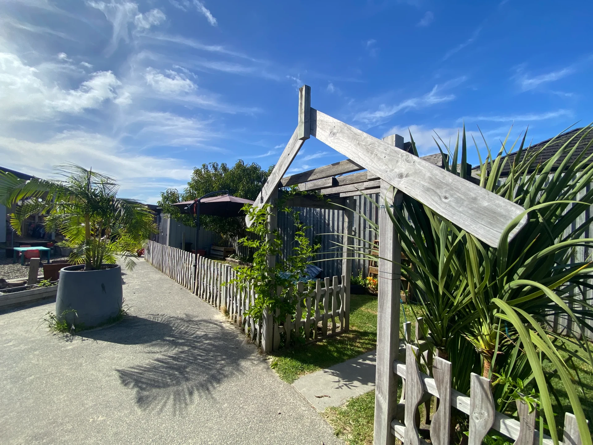 Timber archway and picket fence beside the pathway through the centre gardens