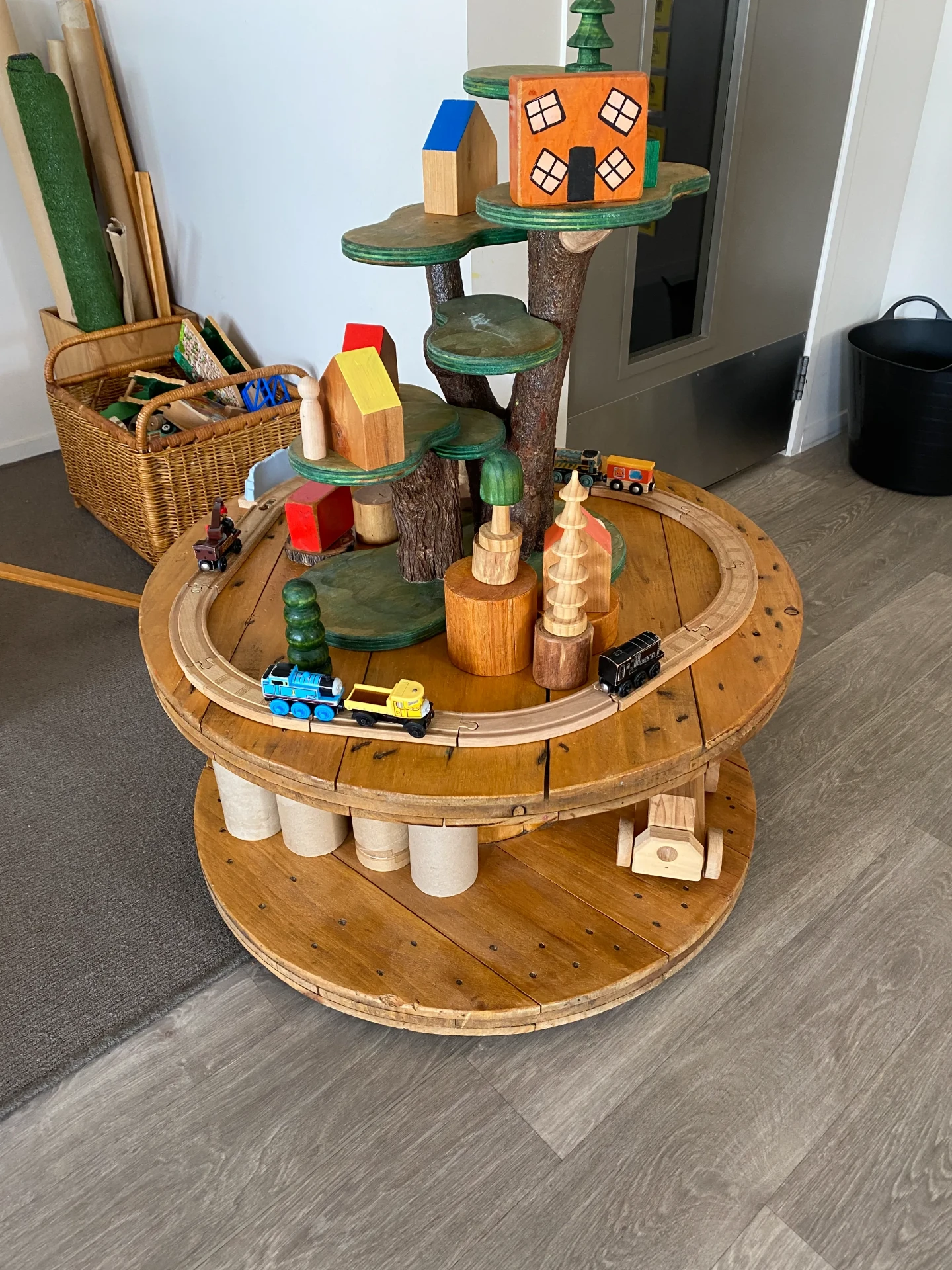 Wooden train table with timber track, tree platforms and painted block houses