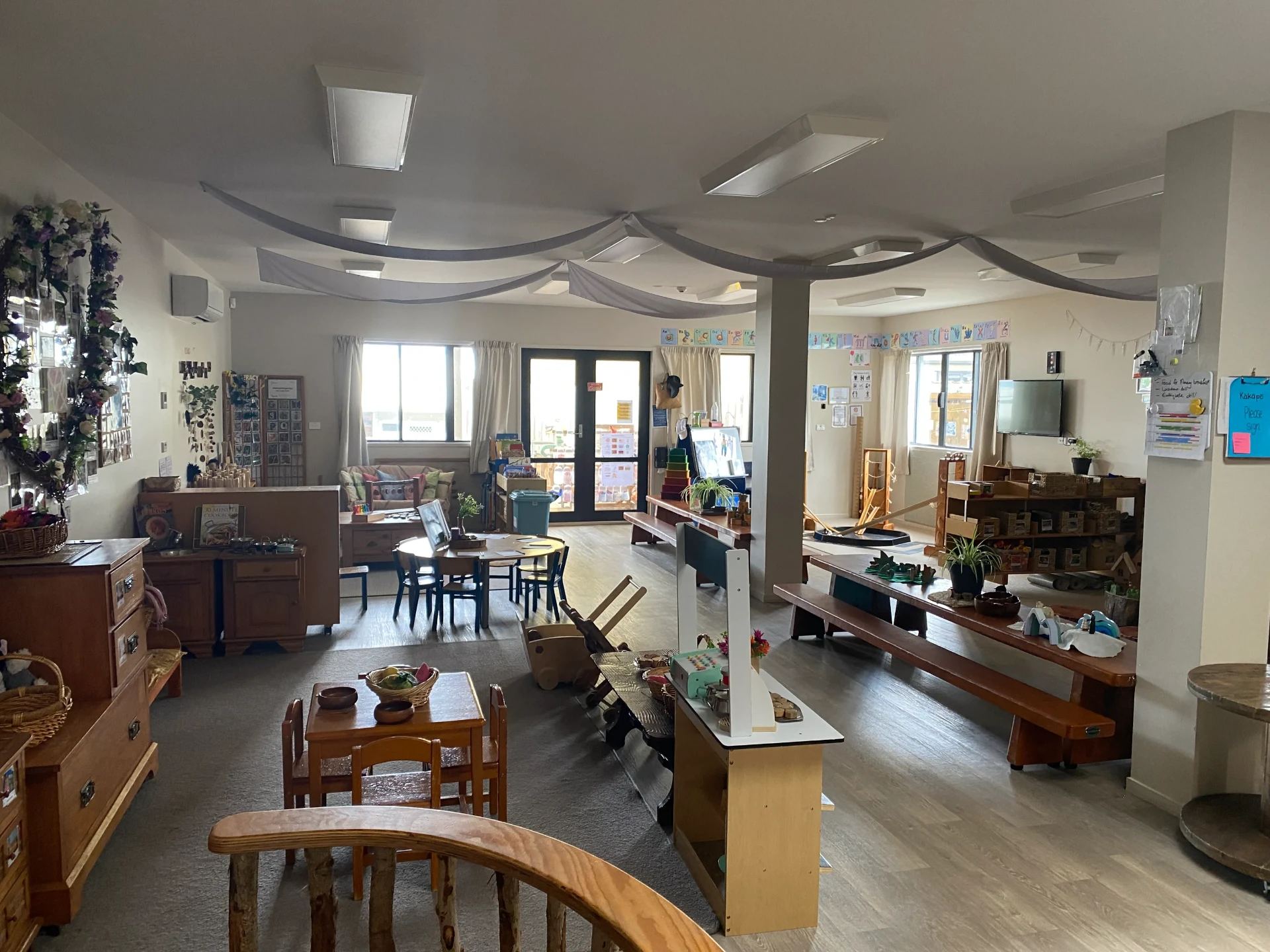 The Kākāpō Room for three to five year olds with tables, literacy displays and open shelving